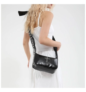 Détail du sac gothique avec croix vintage et bandoulière large ornée de clous