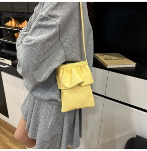 Vue détaillée du sac bandoulière jaune vif avec bords volantés et texture grainée