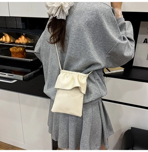 Détail d'un sac bandoulière beige pour téléphone avec texture grainée et volants