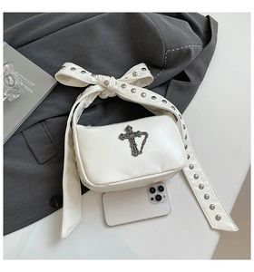 Détail du sac gothique blanc avec croix en métal et bandoulière à nœud clouté