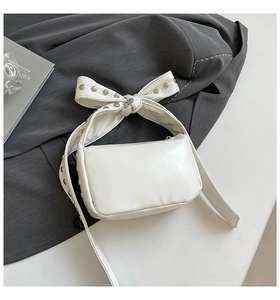 Gros plan du sac gothique blanc avec bandoulière à nœud riveté sur un costume