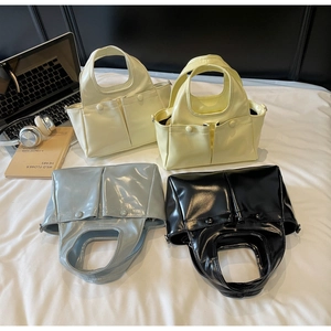 Close-up of glossy pleated tote bags with double front pockets in four stylish colors