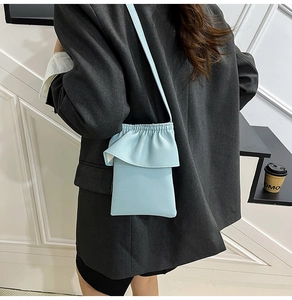 Gros plan du mini sac bandoulière plissé bleu ciel avec cuir texturé et cordon