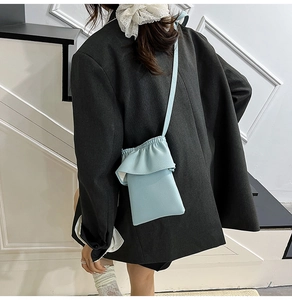 Détail du mini sac de téléphone bleu clair avec rabat à volants et cuir texturé