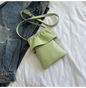 Détail du mini sac de téléphone vert clair en cuir grainé avec bords à volants chic