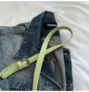 Détail de la bandoulière en cuir vert clair à grain litchi avec boucle en métal argenté