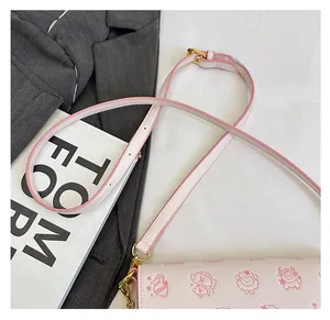 Detail of adjustable pink shoulder strap on chic crossbody bag with cartoon sheep print