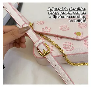 Detail of adjustable pink leather shoulder strap with gold buckle on a crossbody bag