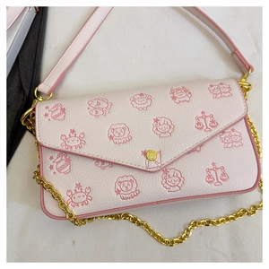 Detail of pink lychee leather crossbody bag with gold chain and zodiac illustrations