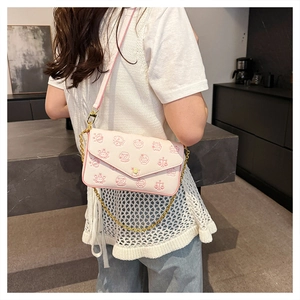 Detail of pink zodiac print crossbody bag showing lychee grain texture and gold chain strap