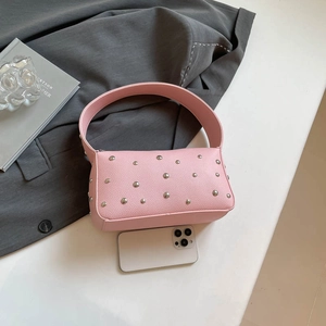 Pink vintage motorcycle bag with silver rivets and litchi grain texture on grey background