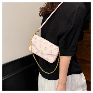 Detail of white PU leather crossbody bag with pink cartoon motifs and gold chain strap