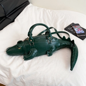 Detail view of the green 3D crocodile bag showing textured faux leather and top handles