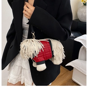 Close-up of creative puppy-shaped crossbody bag with red quilting and white tassels