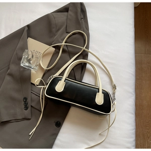 Detailed close-up of contrast stitching and drawstring on a black and white Boston bag