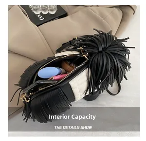 Detail of crossbody bag interior with black fringes showing space for phone and makeup