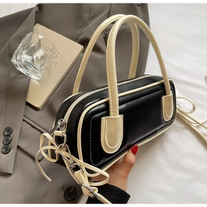 Detail of a two-tone baguette bag with contrast stitching and sturdy double handles