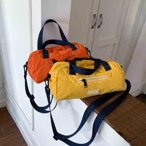 Vibrant nylon duffle bag in yellow and orange with adjustable shoulder strap and logo