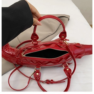Detailed top view of red crocodile-shaped handbag with glossy finish and black lining interior