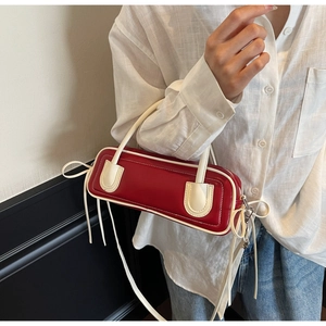 Detailed macro view of retro baguette bag with contrasting red and white colors