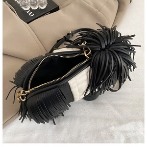 Detail of creative black and white dog-shaped crossbody bag with long leather tassels