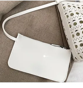 Detail of white hollow-out PU leather tote bag with a small matching zipper pouch