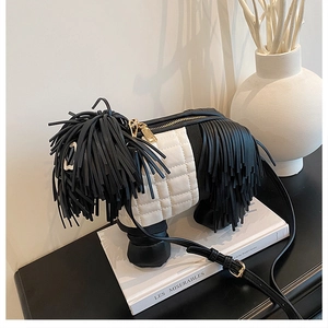 Close-up of creative dog-shaped crossbody bag with black leather fringes and gold zipper