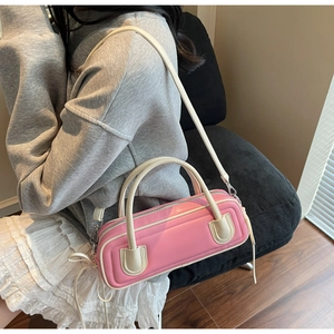 Detail of a pink and cream two-tone barrel bag with side drawstring and leather texture