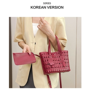 Detail of burgundy cutout leather handbag with adjustable strap and matching inner pouch