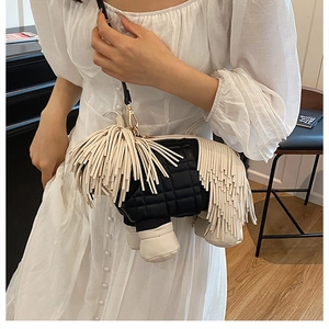 Detail of creative black and white horse-shaped crossbody bag with white fringe tassels