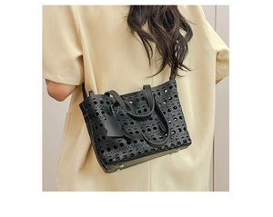 Detailed view of black laser-cut hollow crossbody bag with a cute cat pendant