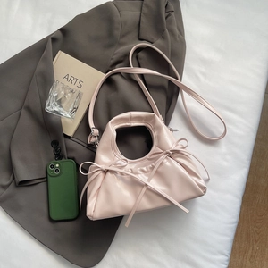 Pink pleated dumpling bag with ribbons and shoulder strap, stylish women's accessory