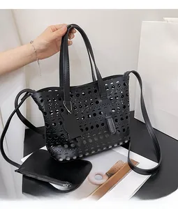 Detailed view of black laser-cut hollow pattern tote bag with a small matching zip pouch