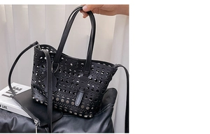 Close-up of black laser-cut hollow tote bag with detachable strap and inner pouch
