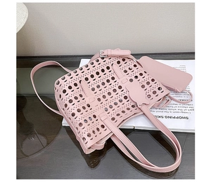 Detail of pink hollow-out tote bag featuring laser-cut holes and small inner pouch