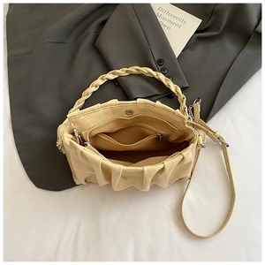 Détail des poignées tressées, poche intérieure zippée et texture plissée du sac beige