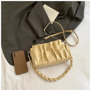 Détail du sac nuage plissé beige avec poignée tressée et accessoires en métal argenté