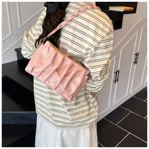 Détail du sac nuage plissé rose avec bandoulière tressée dans un décor de style de vie