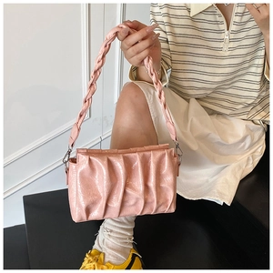 Détail du sac nuage plissé rose avec bandoulière tressée et texture brillante