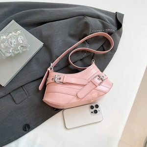 Pink glossy leather shoulder bag with decorative metallic eyelets and adjustable strap