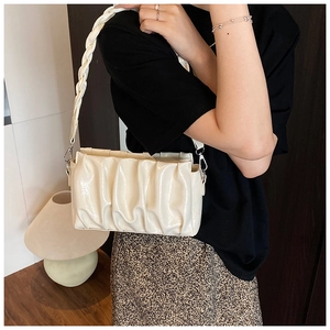 Détail du sac plissé blanc crème avec bandoulière tressée et fini brillant