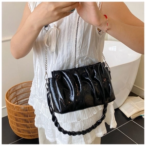 Détail du sac nuage noir plissé avec poignée tressée et bandoulière en chaîne argentée