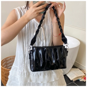 Détail du sac nuage noir brillant avec texture plissée et bandoulière tressée chic