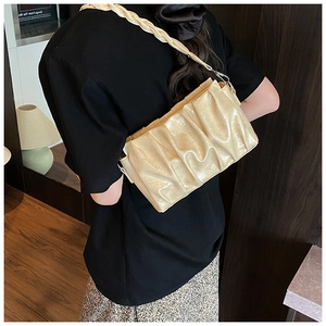 Detail of beige pleated cloud bag with a unique braided strap and silver metal buckle