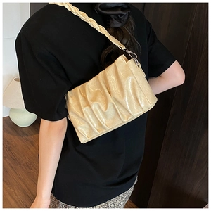 Détail du sac nuage beige plissé avec bandoulière tressée et texture simili cuir brillant