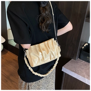Détail du sac nuage plissé crème avec chaîne métallique et bandoulière tissée