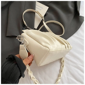 Détail du sac bandoulière plissé blanc cassé avec bandoulière tressée et boucles argentées
