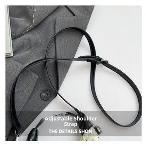 Détail de la bandoulière réglable en similicuir avec boucle en métal argenté sur sac noir