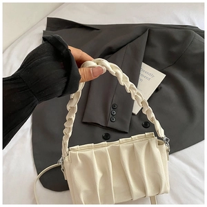 Détail du sac nuage plissé avec poignée tressée et bandoulière réglable amovible