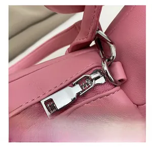 Detailaufnahme von silbernem Reißverschluss und D-Ring an pinker Handtasche